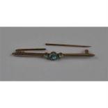 An aquamarine and diamond and set bar brooch, the gently curved yellow metal bar set central round