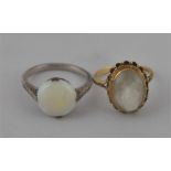 A white metal single stone opal ring, set round cabochon opal displaying green/purple fire, with