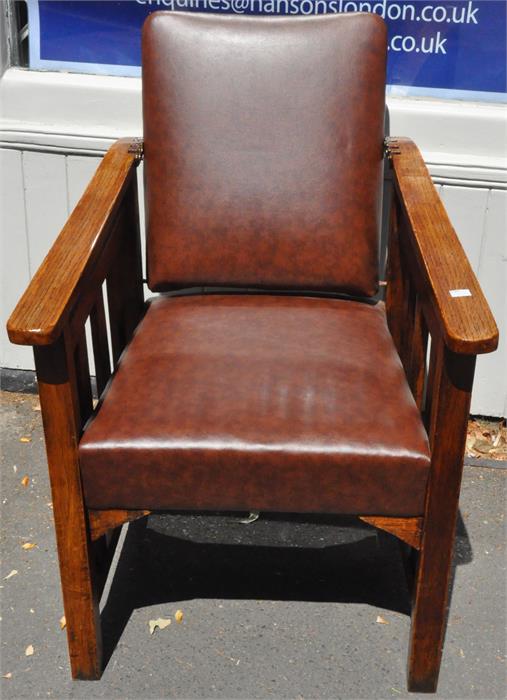 An Arts and Crafts oak reclining chair, having brass mounted four slot ladder for reclining back,