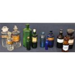 A large collection of clear, blue, green and brown coloured chemist bottles, varying sizes, some