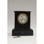 A Victorian black slate eight day mantle clock, the white enamelled dial with black Roman numerals,