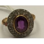 An amethyst and diamond dress ring, set with an oval amethyst with a double row diamond surround,