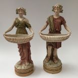 A pair of Royal Dux figures (male and female) carrying wicker baskets,