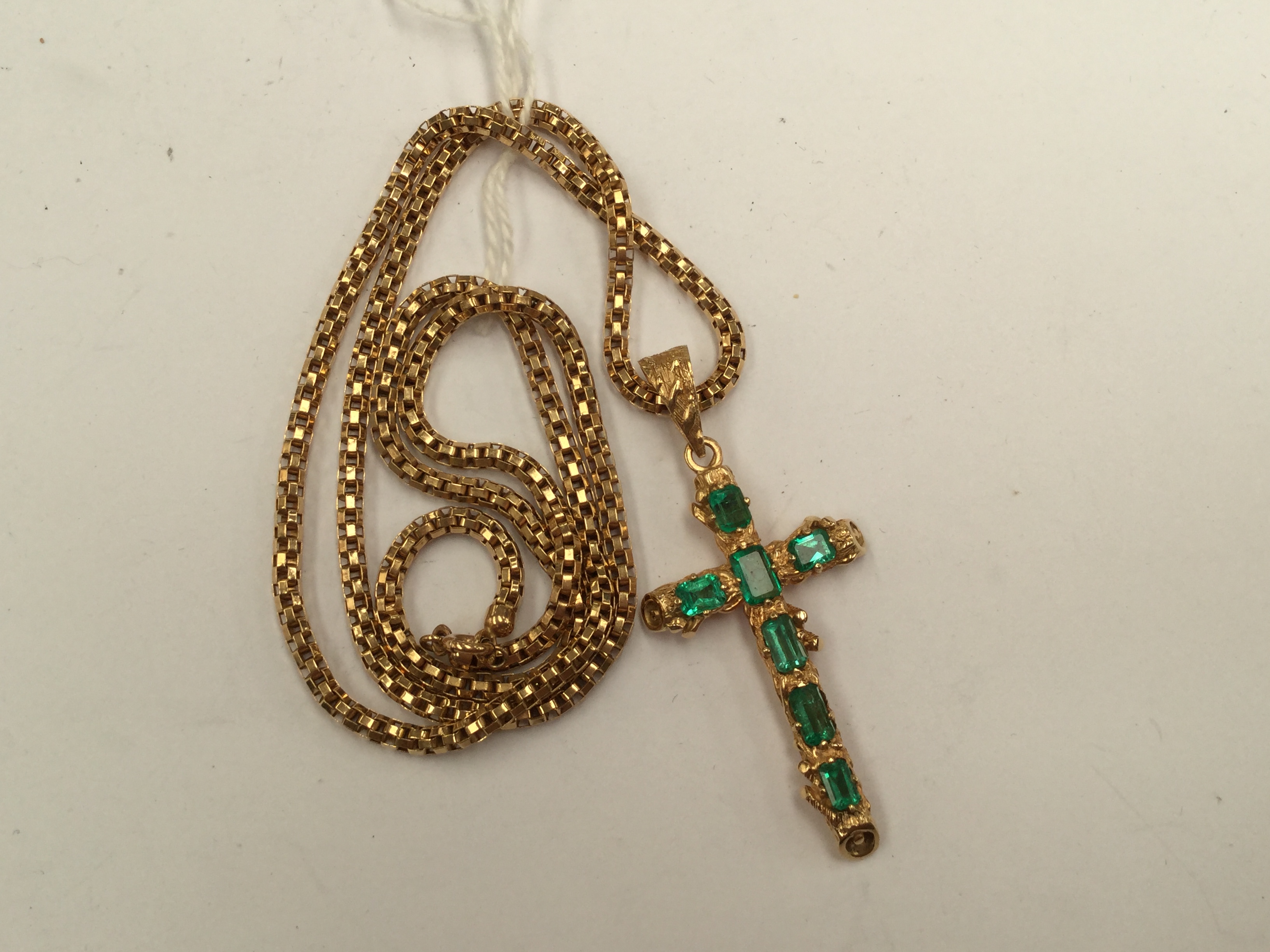 An 18k yellow gold textured crucifix pendant set seven various square cut emeralds; - Bild 2 aus 2
