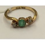 An 18ct gold emerald and diamond three stone ring, 3.