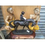 A bronzed model of a horse and jockey on a wooden plinth,