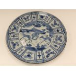 A large Japanese saucer dish painted with five deer in a landscape with overhanging pine,