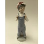 A Lladro figure of a boy. Ref 4898 imprinted to the base.