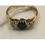 An 18 carat gold three stone ring, central sapphire and two diamonds,