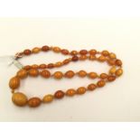 An amber type bead necklace, graduated oval bead, largest bead 17mm, smallest bead 6mm,