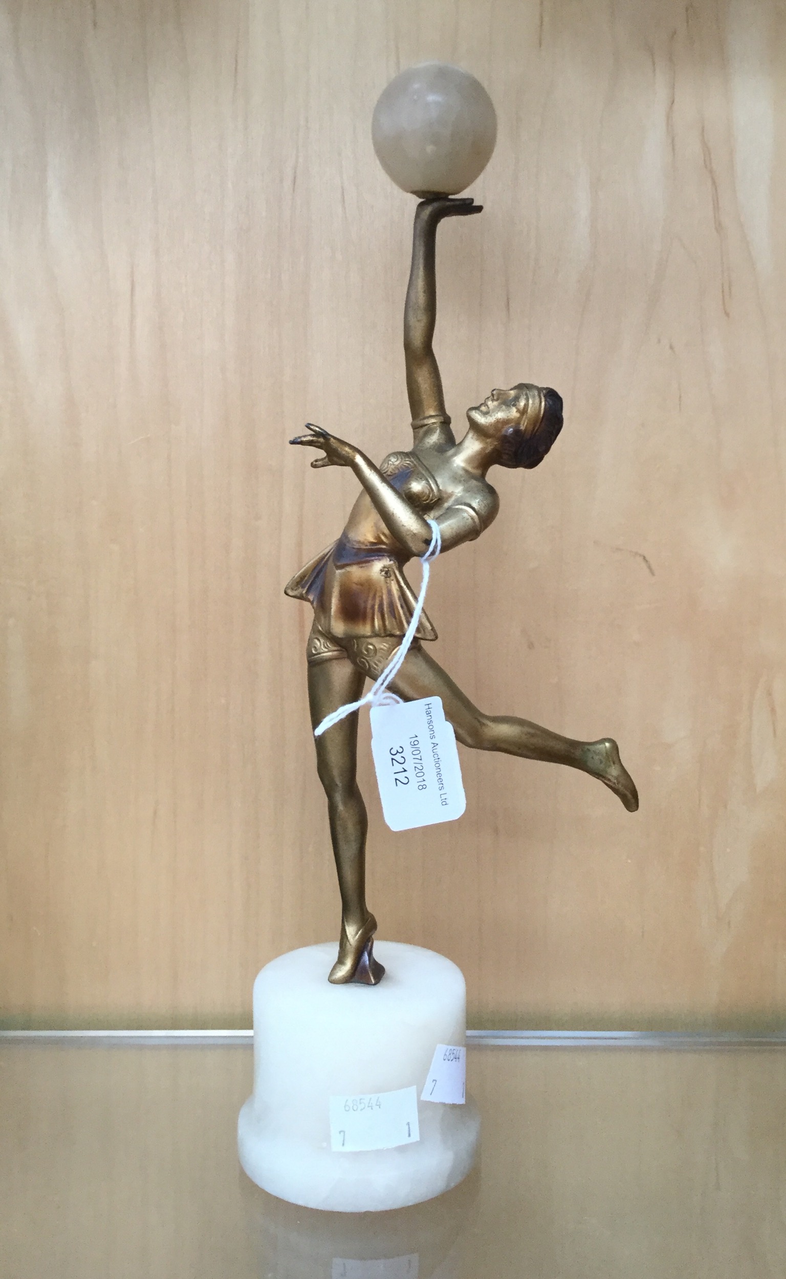 An Art Deco bronze figure of a dancer, holding a marble ball,