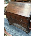 A George II oak bureau, the fall front enclosing a fitted stepped interior,