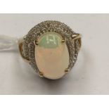 A 9ct gold, opal ring, approx 5.18 ozt, surrounded by white zircons, 5.