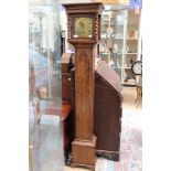 An early 20th Century oak eight day grand daughter clock, having an eight day movement,