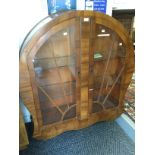 An Art Deco walnut veneered display cabinet, fitted with two glazed doors,