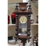 A 19th Century Vienna style wall clock with key and pendulum,