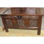 A late 17th Century joined oak chest, having lunette carved frieze, three carved panels,