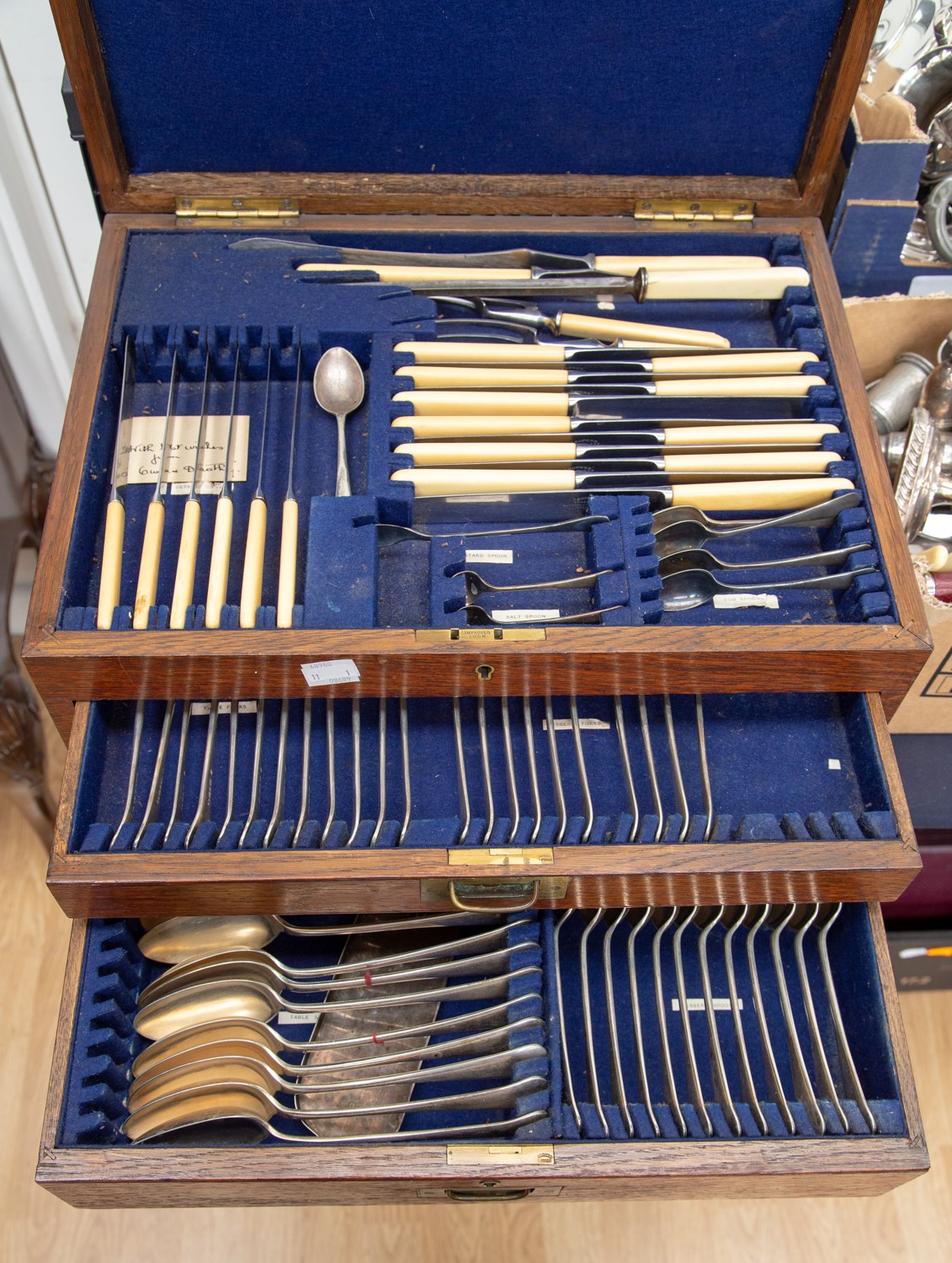 An oak canteen of cutlery, two drawers with hinged cover, including sauce ladles, knife rests, etc,