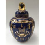 A Carlton Ware bulbous bowl and cover, having Egyptian gilt decoration on a blue lustre ground,