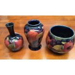 AThree Moorcroft pomegranate small vases; baluster vase with narrow neck,