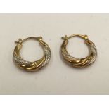 A pair of white and yellow metal hoop earrings