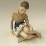 A Royal Doulton 'Treasure Island' figure of a boy reading a book,