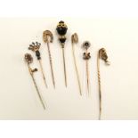 An Edwardian gold stick pin in the form of a coronet set five sapphires and seed pearls,