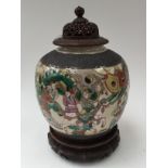 A circa 1920s Japanese pot pourri jar, having hardwood stand and pierced hardwood cover,