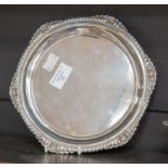 An early 20th Century silver circular waiter, with gadroon and shell border, on three scroll feet,