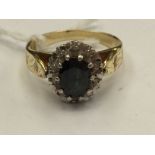 An 18ct sapphire and diamond cluster ring, having oval cut green/blue sapphire to centre,