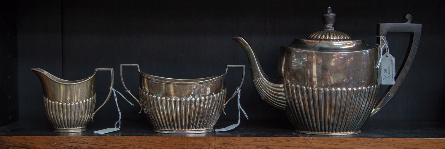 A matched silver three piece teaset, reeded boat form, various makers and dates, Sheffield, 29.