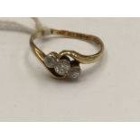 An 18ct gold and diamond crossover ring, set central round brilliant cut diamonds to either side,