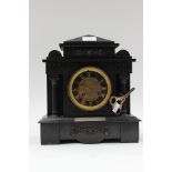 A black slate, 8 day mantle clock, Roman numerals on black and guilded dial,