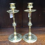 A pair of Arts and Crafts brass candle holders, each having four clear cabochon stones,