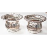 A pair of large silver plated champagne bottle coasters,