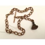 A rose gold 9ct gold watch fob chain with a gilt metal fob set with camelian, toggle clasp and T.