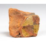 A ceramic tile fragment from the Thames foreshore. Terracotta colour with yellow roundel to the