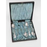 A boxed set of four silver teaspoons and tongs