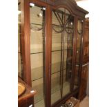 An Edwardian mahogany display cabinet, glazed door, glass shelves,