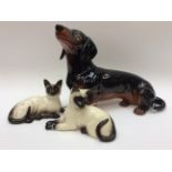 A large Beswick Dacshund together with a pair of Doulton Beswick cats,