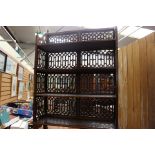 A four tier fretwork bookshelf, possibly Chinese, of recent manufacture, 121cm high, 82cm wide,
