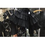 A black short silk and tulle cape 1870 in tiers with pinked edging;