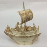 An early 20th century Chinese carved ivory junk boat with three male figures with cockeral head