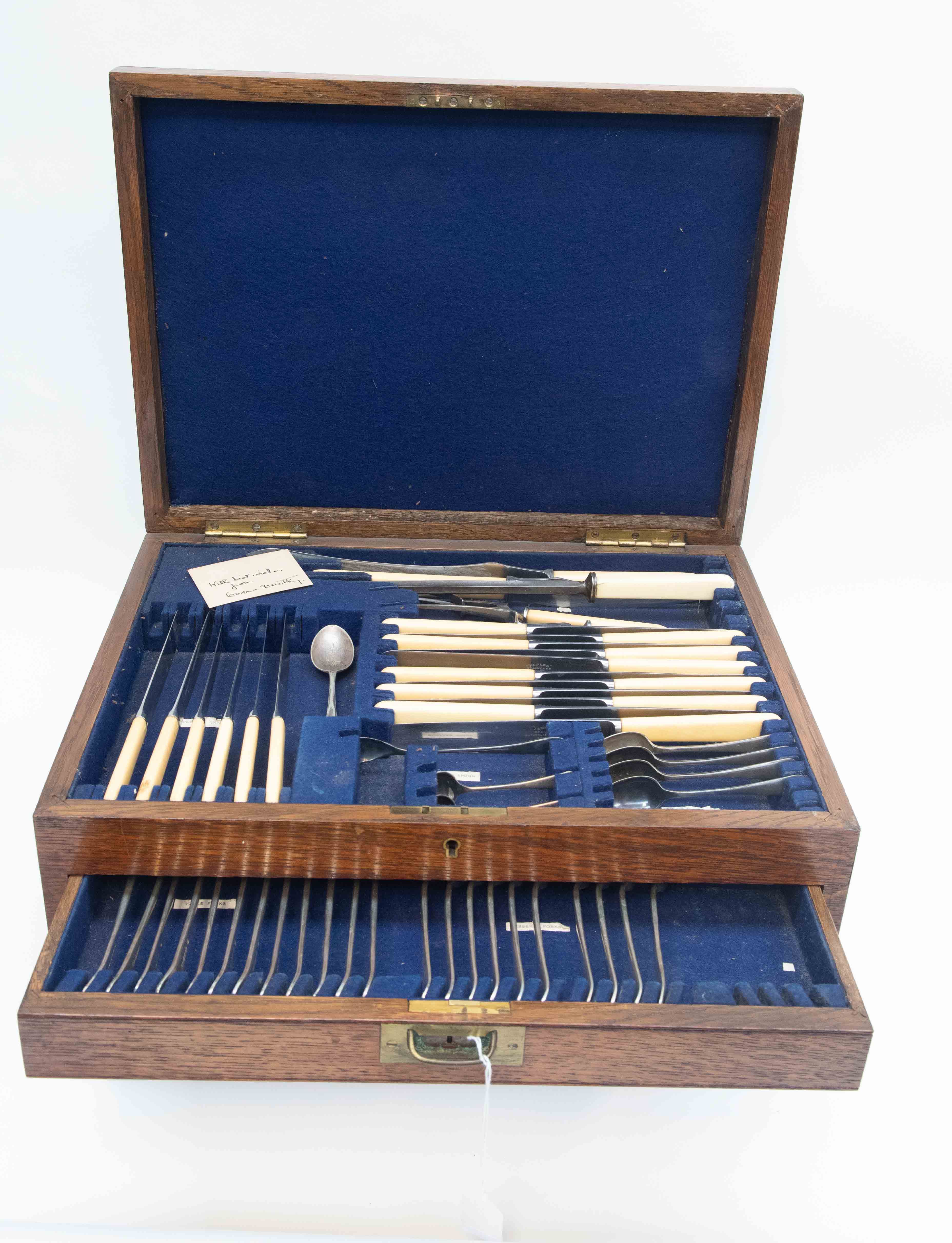 An oak canteen of cutlery, two drawers with hinged cover, including sauce ladles, knife rests, etc,