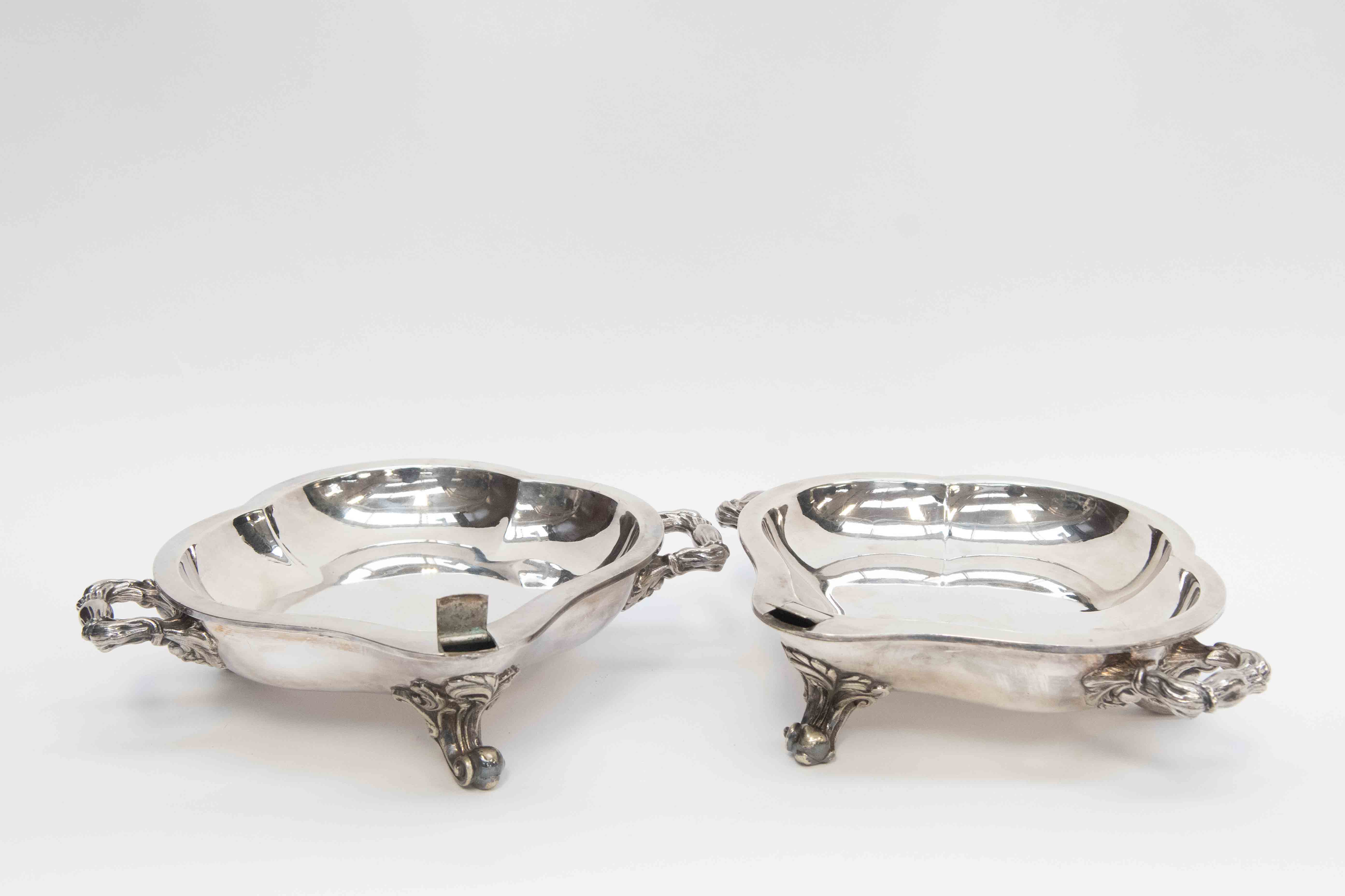 A pair of silver plated muffin dishes on three scroll feet,