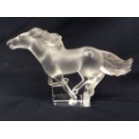 A Lalique glass galloping horse. Original lalique sticker to plinth. Signed 'Lalique France'.
