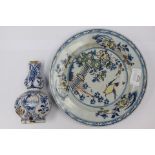 An 18th century tin glazed earthenware plate and a Delft bottle vase (2) s/d