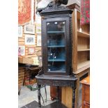 A late Victorian oak free standing corner cupboard, fitted with a single glazed door,