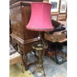 An Edwardian brass tripod floor lamp with a circular tier shelf, silk shade,