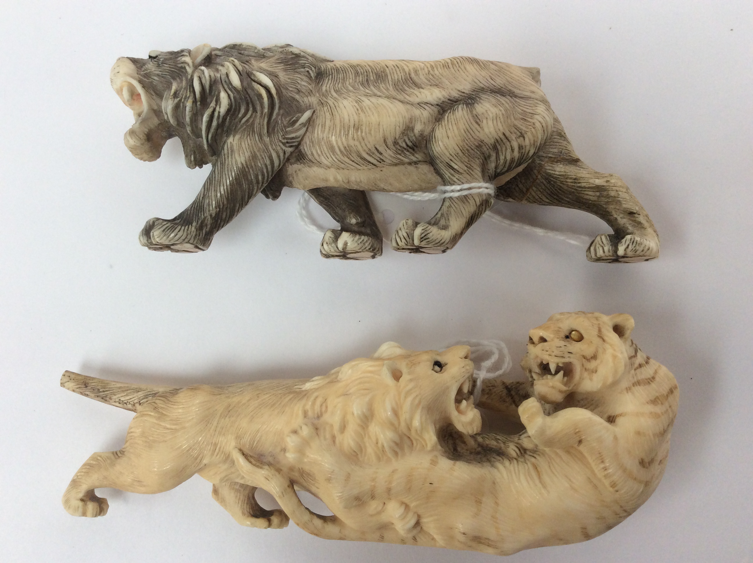 Two carved antique ivory figures of tigers fighting (a/f)
